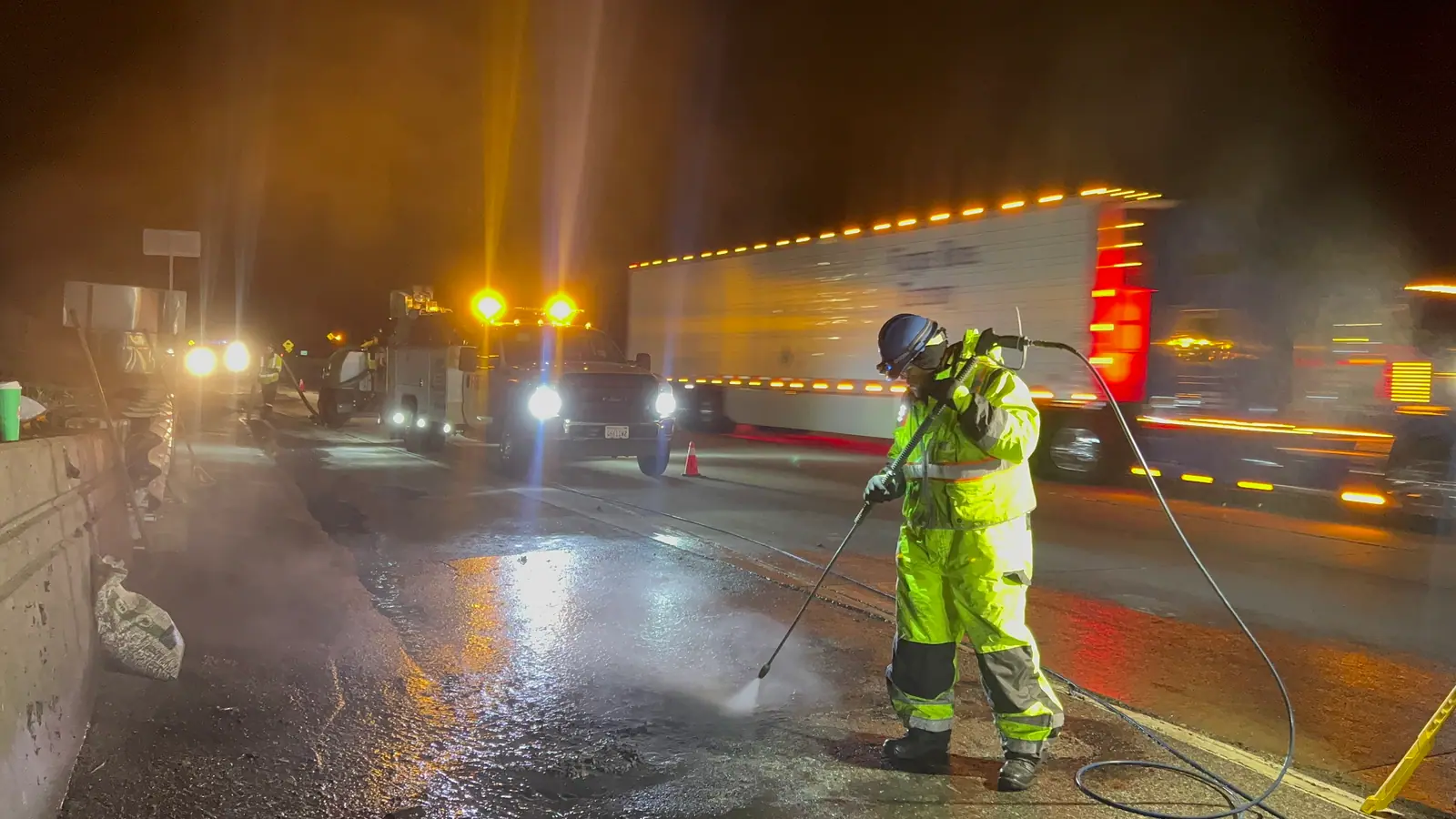 Emergency spill response crew cleaning a Lancaster CA roadway at night
